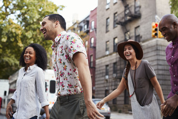 Group Of Friends Walking Along Urban Street In New York City