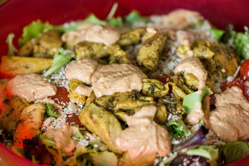 Macro shot of sunflower seeds, sesame, lin seeds on top of red cherry tomatoes next to parmesan cheese, lettuce, chicken. Freshly made caesar salads with dressing. Healthy vegetables, food in summer