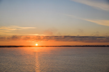 Golden, colorful, abstract sea sunrise view at horizon, vibrant sky landscape and small waves in the water