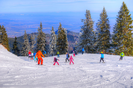 People practicing ski sport on the slope in winter holiday in Poiana Brasov resort, Romania,
