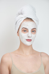 Facials. A girl with a towel on his head and a mask on her face