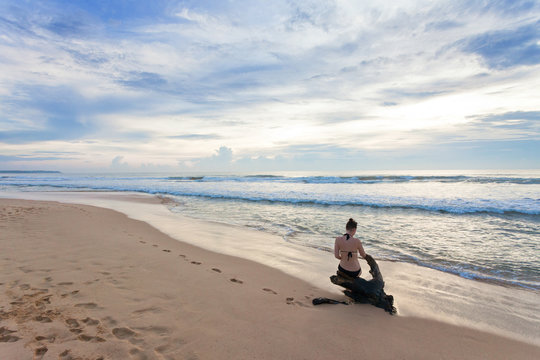 Sri Lanka - Ahungalla - A woman sitting on a stump at the beach