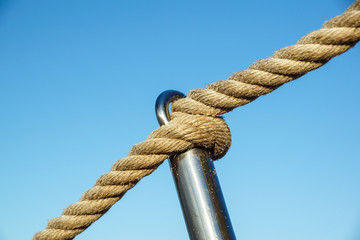 rope on metal pole, railing of beach walkway