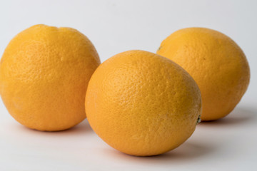 three oranges on a white background