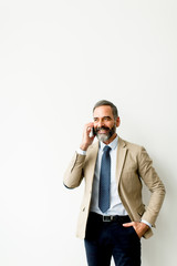 Fototapeta premium Handsome mature businessman with mobile phone in the office
