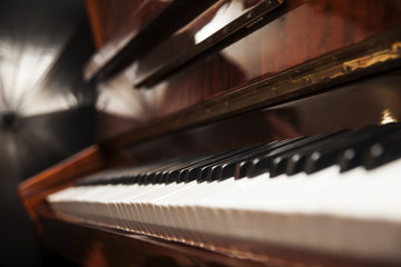 Piano keys on wooden brown musical instrument