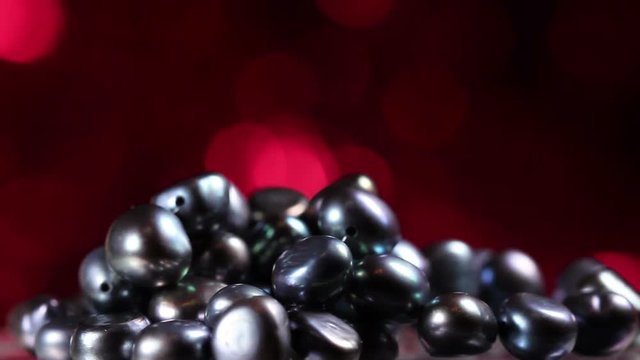 Black Pearls Close up Macro With Red Glitter Texture On Background.