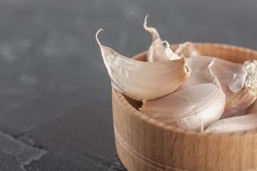 garlic in a wooden bowl on a black background