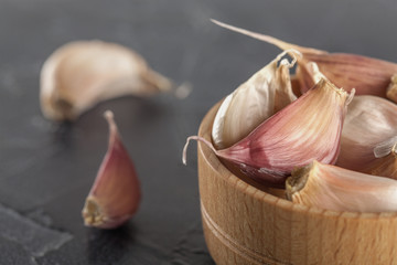 garlic in a wooden bowl on a black background