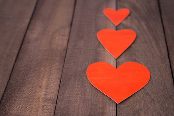 Three red heart on the background of old wood