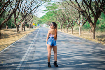 Portrait of sexy asian woman on the road under tunnel trees,Lifestyle of modern thailand woman