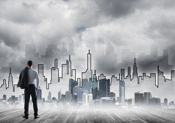 Motivation and inspiration concept with modern cityscape and businessman observing it