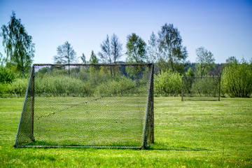 Handmade soccer gates in the middle of meadow at countryside. Kids playing football and having fun