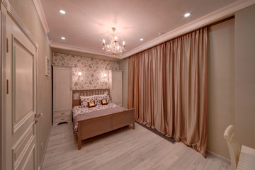 The light cream bedroom with a big bed, pillows and cases for clothes