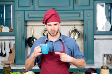 Guy point finger at blue cup in kitchen