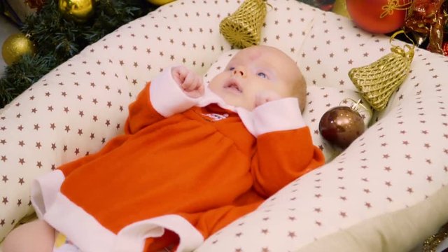Adorable two-month girl in red dress celebrates her first Christmas