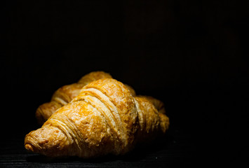 two croissants on dark wooden background. with copy space.