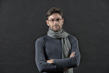 Man in scarf and sweater with folded hands