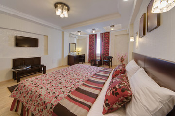 The bedroom with multi-colored curtains and a multi-colored cover