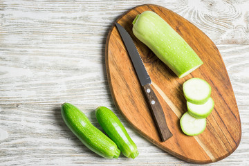 Fresh summer squash sliced and zucchini on white wooden background. Top view, space for text. 