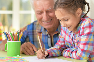 Grandfather with granddaughter drawing together