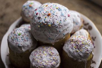 Easter cake with white icing and sprinkled with little candies on the plate on the window sill. A...