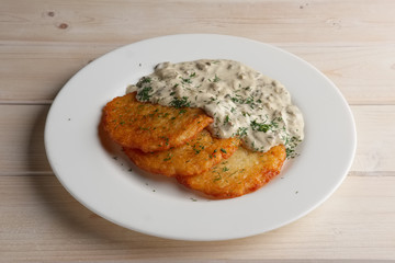 Traditional belorussian potato pancakes draniki with mushroom sauce