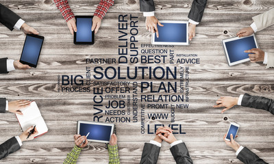 Top view of businesspeople sitting at table and using gadgets