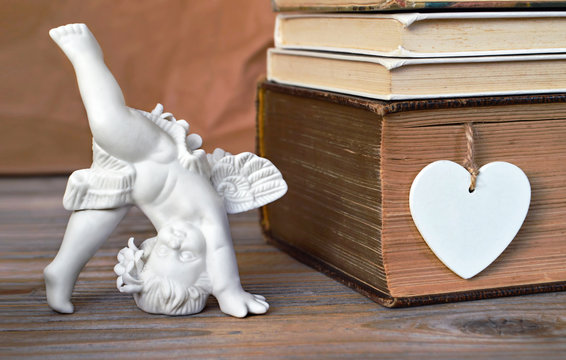 Angel figurine and heart decoration on wooden background