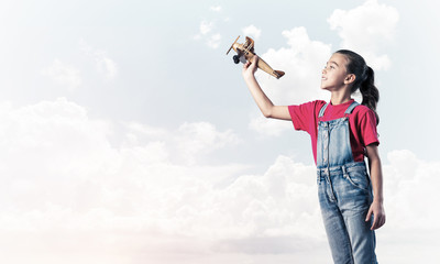 Concept of careless happy childhood with girl dreaming to become