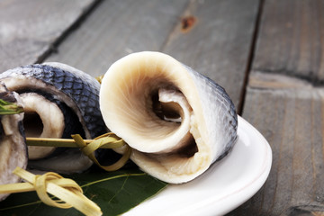 Traditional rollmops, stuffed pickled herring fillets,on a dish