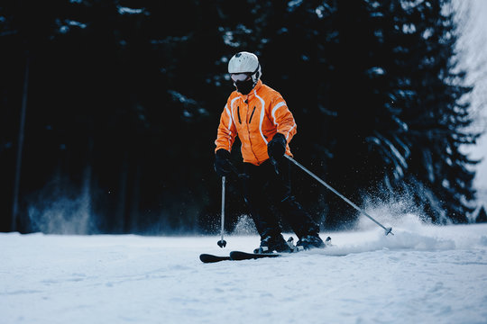 Male skier on a slope in the mountains. Frozen dark forest in the background. Skier in winter forest mountains skiing downhill