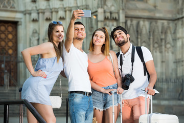 Obraz premium tourists taking selfie on camera in smartphone