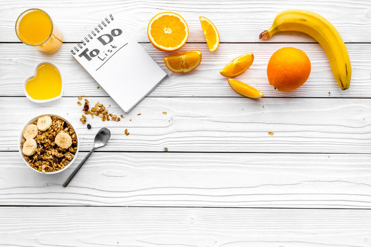 Start the day the right way. Healthy breakfast oatmeal with fruits and planning the day. White wooden background top view copyspace