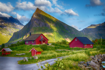 rote Holzhütten vor einem Berg, Lofoten