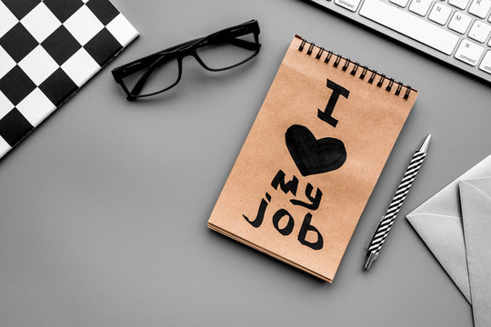 Find dream job. Handwritten motto I love my job in notebook on office desk on grey background top view copyspace