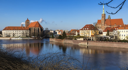 Fototapeta na wymiar Panoramic view of Ostrow Tumski district in Wroclaw city with Collegiate Church of the Holy Cross and St Bartholomew, Cathedral of St John the Baptist, Archbishop's, palace from Oder River.