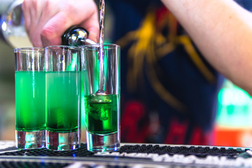 Three multi-layer burning cocktail. The bartender ignites them lighter.