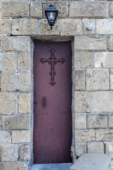 Narrow metal door at a Greek Orthodox church.