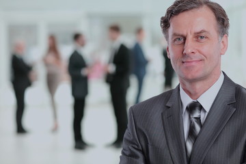 Happy mature business man looking at camera with satisfaction at office