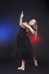 Cute gymnast posing looking at camera. Teenage girl wearing black transparent dress