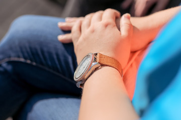 watch with leather strap on the girl's hand