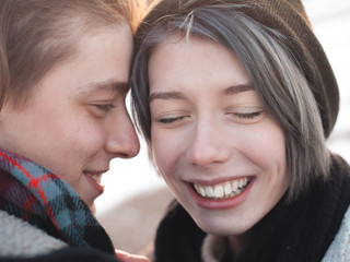 A happy  young man and woman outdoors at sunset. Winter