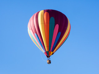 Colorful hot air balloon flying in the bright blue sky during Winthrop Balloon Festival in Washington state