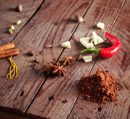 Anise red pepper white chocolate and cocoa powder on brown wooden table