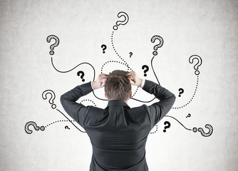 Businessman in terror, question marks
