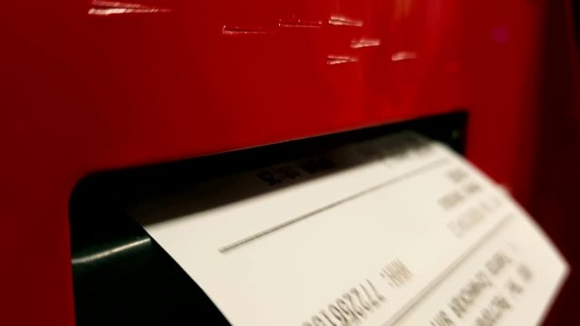 The machine prints a receipt. Woman's hand takes it. Close up.
