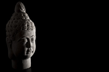 East asian culture and Buddhism concept with Buddha face and head statue made of white gypsum isolated on black with copy space