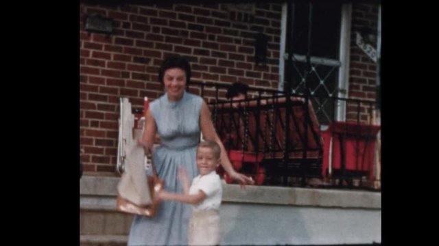 1957 Mother Smoking cigarette kisses young son then posses for camera