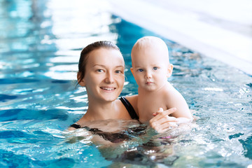 Smiling charming baby in swimming pool